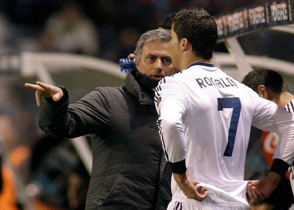 epa03597522 Real Madrid's Portuguese head coach Jose Mourinho (L) gives instructions to Portuguese striker Cristiano Ronaldo as Ronaldo is to come out on to the pitch during the Spanish Primera D ...