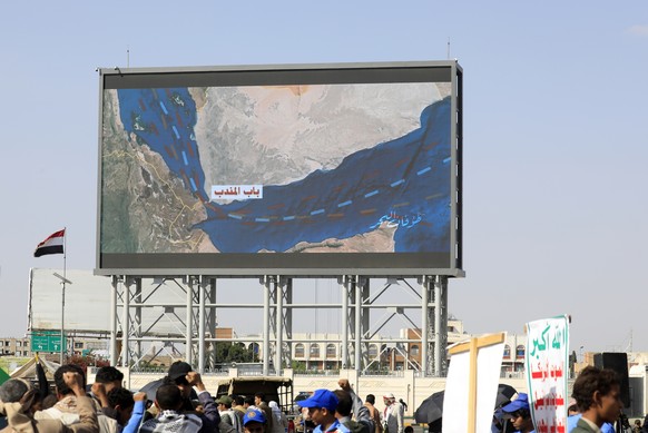 epa12428478 Houthi supporters gather in front of a digital billboard featuring a map of the Bab al-Mandab Strait, linking the Gulf of Aden and the Red Sea, during a protest against Israel, in Sana ...