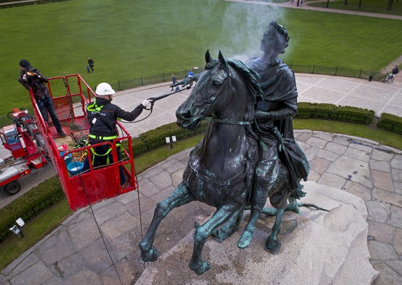A worker washes a city landmark, the equestrian statue of Peter the Great known as the Bronze Horseman by French sculptor Etienne Maurice Falconet, in St.Petersburg, Russia, Friday, May 26, 2017. (AP  ...