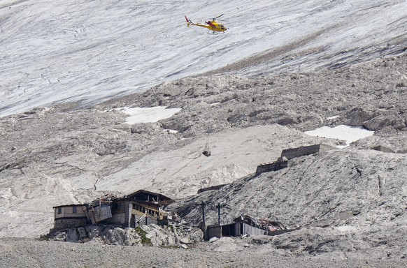 A rescue helicopter carries technical equipment on the Punta Rocca glacier near Canazei, in the Italian Alps in northern Italy, Tuesday, July 5, 2022, where an avalanche broke loose on Sunday, sending ...