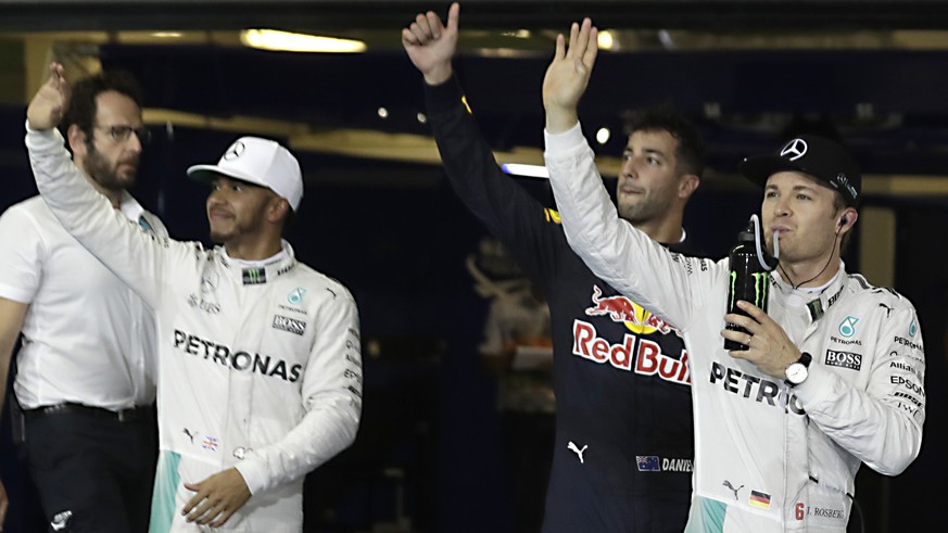 From left to right, Mercedes driver Lewis Hamilton of Britain, Red Bull driver Daniel Ricciardo of Australia and Mercedes driver Nico Rosberg of Germany wave from the pits as they head toward the podi ...