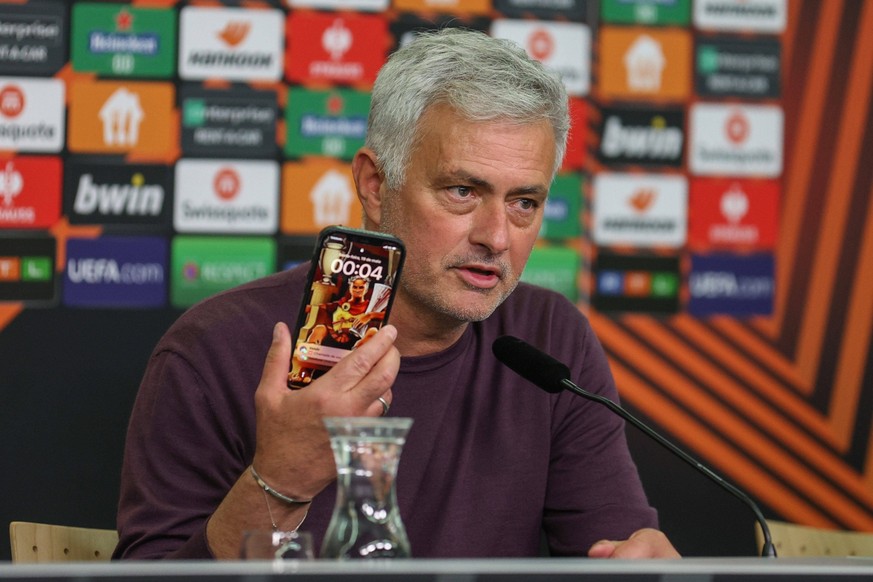 Europa League - Bayer 04 Leverkusen - AS Rom am 18.05.2023 in der BayArena in Leverkusen Jose Mourinho Roma hält auf der Pressekonferenz sein Smartphone hoch, auf dem Sperrbildschirm sitzt ein Römer m ...