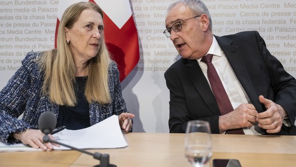 Swiss Federal Councillor Guy Parmelin, right, and Helene Budliger Artieda, State secretary for economy, talk after informing during a press conference on the new import tariffs into the US, Friday, No ...