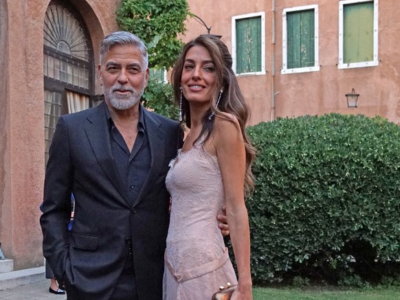 epa10831902 US actor George Clooney (L) and his wife Amal Alamuddin arrive to attend the ceremony for the Diane Von Furstenberg Award (DVF), in the Sala degli Arazzi of the Giorgio Cini Foundation in  ...