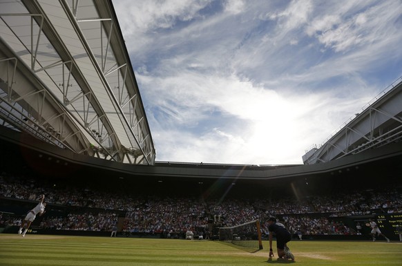 Roger Federer of Switzerland (L) serves during his men&#039;s singles semi-final tennis match against Milos Raonic of Canada at the Wimbledon Tennis Championships, in London July 4, 2014. REUTERS/Stef ...