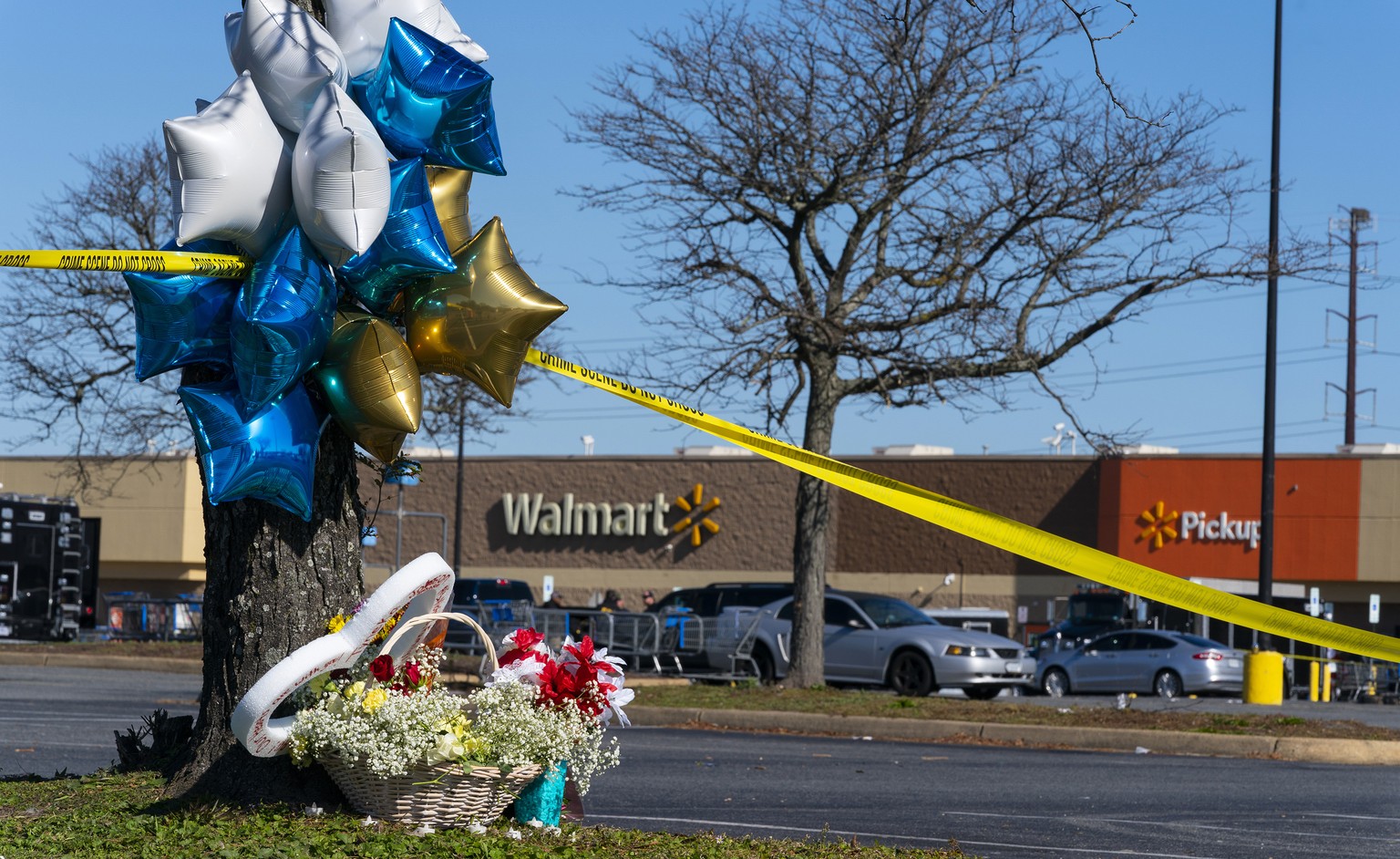 Flowers and balloons have been placed near the scene of a mass shooting at a Walmart, Wednesday, Nov. 23, 2022, in Chesapeake, Va. A Walmart manager opened fire on fellow employees in the break room o ...