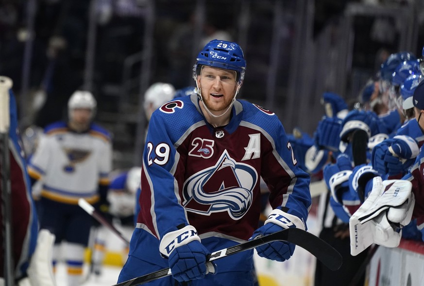 FILE - In this May 19, 2021, file photo, Colorado Avalanche center Nathan MacKinnon is congratulated at the bench after scoring his second goal of night in the third period of Game 2 of an NHL hockey  ...