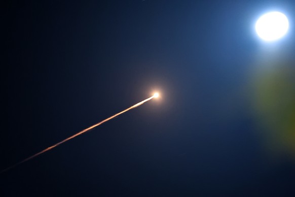 epa12793109 The moon shines as Israel's Iron Dome air defense systems intercept projectiles over Tel Aviv, Israel, 03 March 2026. The Israeli military reported that it detected missiles launched  ...