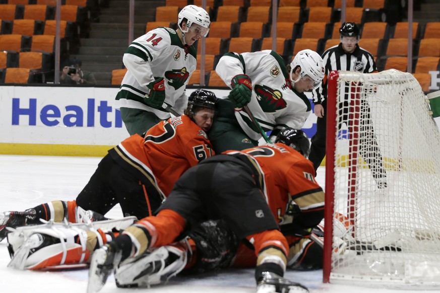 Minnesota Wild left wing Kevin Fiala, center top, scores against Anaheim Ducks center Rickard Rakell, bottom left, defenseman Trevor Carrick, bottom right, and goaltender John Gibson, below, with cent ...