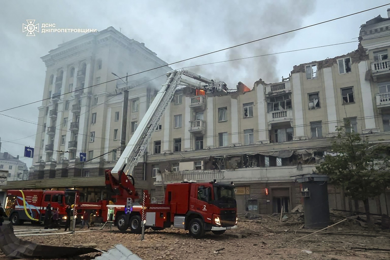 epa11287726 A handout photo made available by the State Emergency Service shows Ukrainian rescuers working at the site of a rocket attack on a residential building in the city of Dnipro, Dnipropetrovs ...
