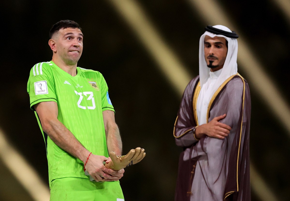 epa10373090 Argentina's goalkeeper Emiliano Martinez (L) poses after receiving the Golden Glove award as best goalkeeper of the tournament after the FIFA World Cup 2022 Final between Argentina an ...
