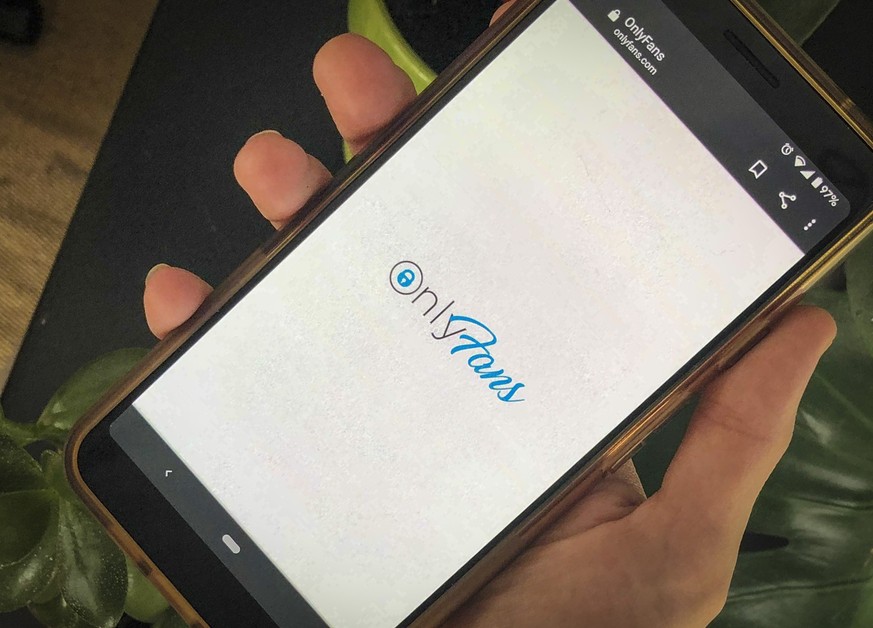 This photo shows a phone app for OnlyFans, a site where fans pay creators for their photos and videos, Thursday Aug. 19, 2021. A spokesperson says the site will ban &quot;sexually explicit&quot; start ...