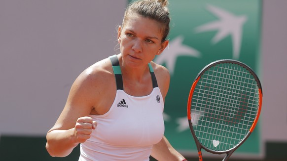 Romania&#039;s Simona Halep clenches her fist after scoring a point against Spain&#039;s Carla Suarez Navarro during their fourth round match of the French Open tennis tournament at the Roland Garros  ...