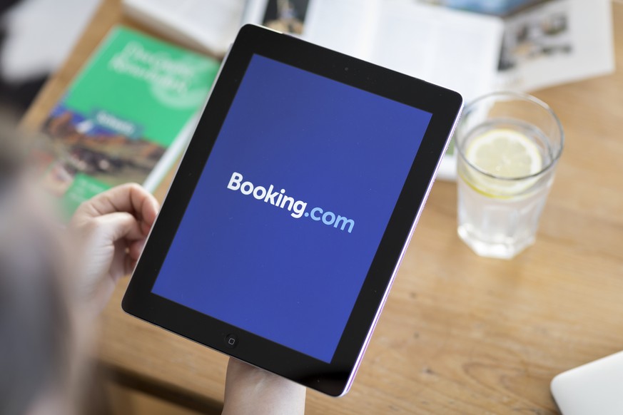 ARCHIV - ZUM VORGEHEN DES PREISUEBERWACHERS GEGEN BOOKING.COM STELLEN WIR IHNEN DIESES ARCHIVBILD ZUR VERFUEGUNG - A person visits the website of the online travel agency Booking.com on an ipad, pictu ...