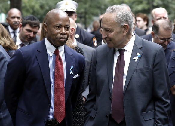 epa10178188 New York City Mayor Eric Adams (L) speaks with US Senate Majority Leader from New York Chuck Schumer during a ceremony at the 9/11 Memorial marking the 21st anniversary of the September 11 ...