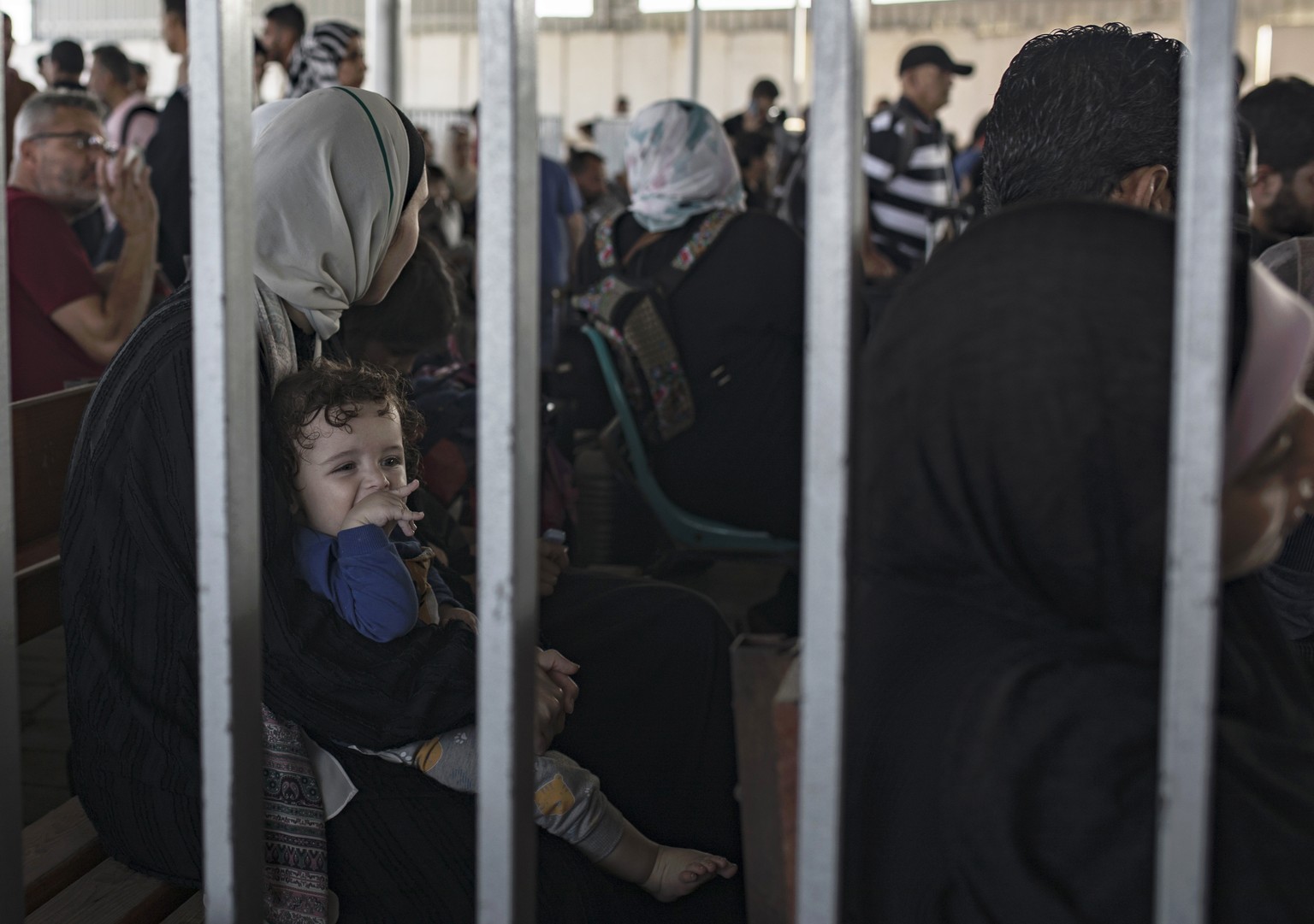 epa10952646 Palestinians wait to cross into Egypt at the Rafah border crossing between the Gaza Strip and Egypt, in Gaza, 01 November 2023. Ambulances carrying evacuees from the Gaza Strip were driven ...