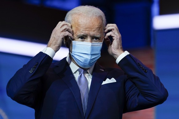 FILE - In this Nov. 24, 2020, file photo President-elect Joe Biden puts on his face mask after introducing nominees and appointees to key national security and foreign policy posts at The Queen theate ...