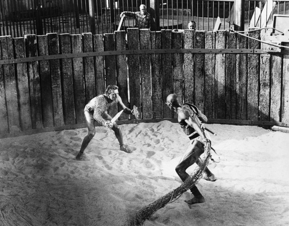 FILE - In this April 1959 file photo, actor Kirk Douglas, left, in the title role as a Roman slave and gladiator, battles Woody Strode in the role of gladiator Draba in a scene from &quot;Spartacus&qu ...