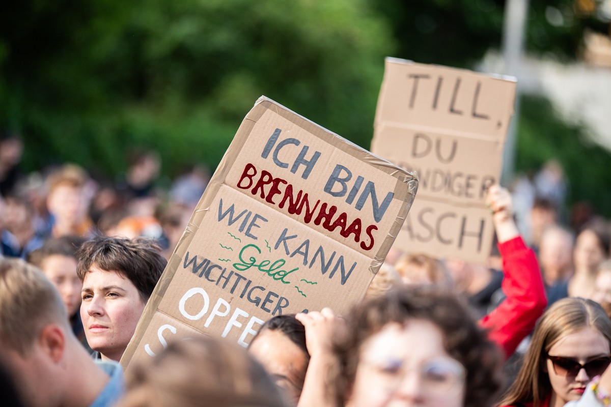epa10770157 A person holds a placard 'very angry � I am very angry, How can money be more important than victims?' as People take part in a demonstration �No stage for suspected perpetrators ...