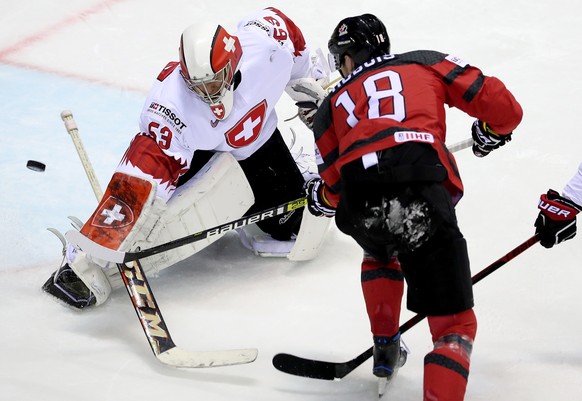 epa07594513 Pierre-Luc Dubois of Canada (R) in action with goalkeeper Leonardo Genoni of Switzerland during the IIHF World Championship quarter final ice hockey match between Canada and Switzerland at ...