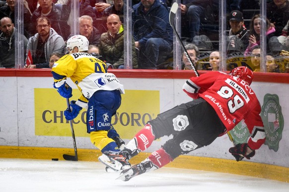Dominik Egli (HCD), gauche, lutte pour le puck avec Cody Almond (LHC), droite, lors du match acte 3 du quart de finale de play-off du championnat suisse de hockey sur glace de National League entre La ...