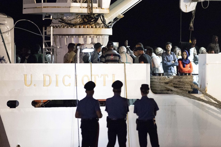 epa06824529 Migrants descend from the Diciotti, an Italian Coast Guard patrol boat, carrying over 500 migrants rescued in recent days in the Mediterranean and a corpse in the port of Pozzallo, Sicily  ...