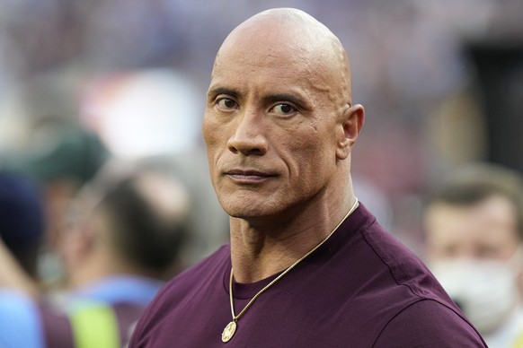 Dwayne &quot;The Rock&quot; Johnson stands on the field before the NFL Super Bowl 56 football game between the Los Angeles Rams and the Cincinnati Bengals, Sunday, Feb. 13, 2022, in Inglewood, Calif.  ...