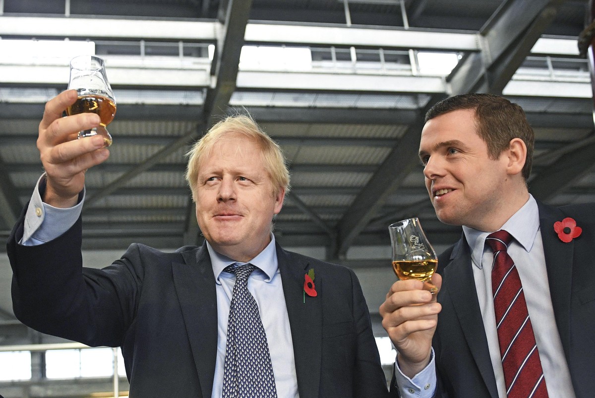 FILE - In this file photo dated Nov. 7, 2019, showing Britain's Prime Minister Boris Johnson alongside Douglas Ross, parliamentary under-secretary of state for Scotland, right in Moray, Scotland. ...