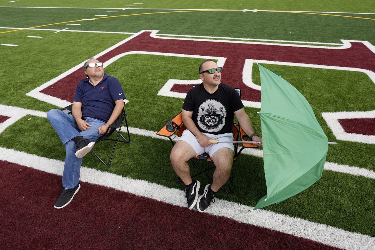 Joe and Ric Solis use special glasses as they prepare to watch a total solar eclipse in Eagle Pass, Texas, Monday, April 8, 2024. (AP Photo/Eric Gay)