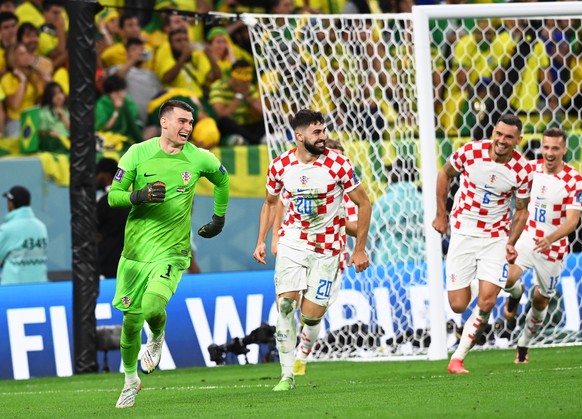 epa10357603 Croatia&#039;s goalkeeper Dominik Livakovic (L) and teammates celebrate after winning the penalty shoot-out of the FIFA World Cup 2022 quarter final soccer match between Croatia and Brazil ...