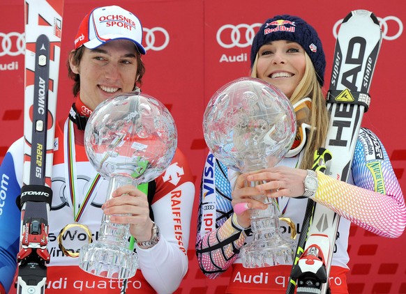 Lindsey Vonn of the United States, right, and Switzerland's Carlo Janka hold their trophies of the alpine ski, Women's and Men's World Cup overall title, in Garmisch-Partenkirchen, Germ ...