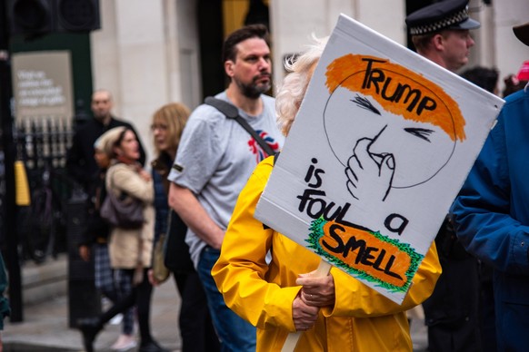 September 17, 2025, London, England, United Kingdom: A protestor holds a placard during the Trump not welcome demonstration at Parliament Square. Around 50 protest groups were expected to gather toget ...