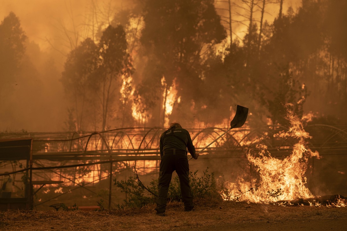 epa12307328 A forest guard works to extinguish a forest fire in Carballeda de Avia, Ourense, Galicia, north-western Spain, 17 August 2025. Multiple blazes continue to affect several provinces in Spain ...
