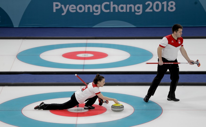 Switzerland Jenny Perret throws a stone beside teammate Martin Rios during a mixed doubles curling match against Canada&#039;s Kaitlyn Lawes and John Morris at the 2018 Winter Olympics in Gangneung, S ...