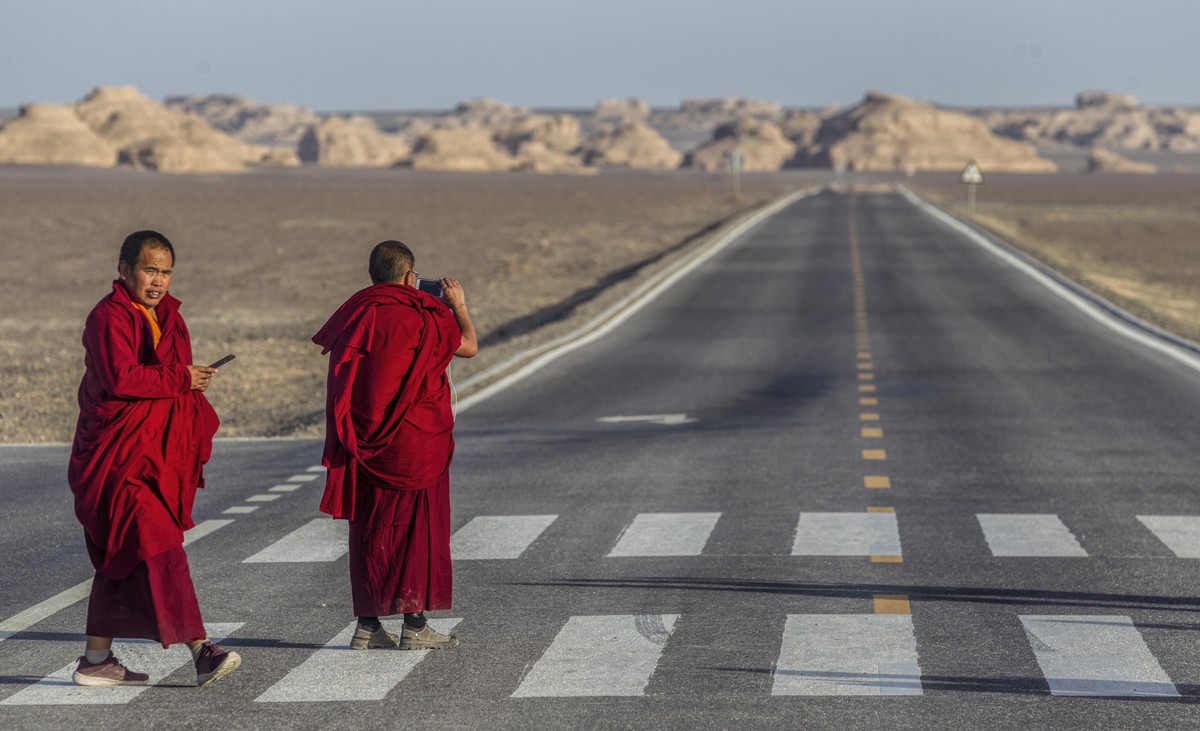 epaselect epa07060837 Buddhist monk's cross the desert road in Yardang Geopark also known as Devil’s Town near Dunhuang, Gansu Province, China, 29 September 2018, (issued 01 October 2018). Dunhua ...