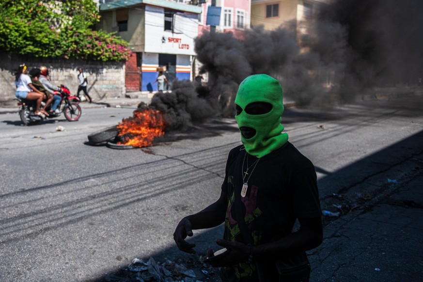 epa11192516 A hooded man is seen on the streets, in Port-au-Prince, Haiti, 01 March 2024, a day after gang violence left at least five dead and twenty injured. According to the latest report from the  ...