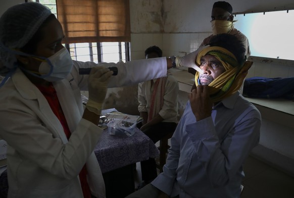 An Indian doctor checks a man who recovered from COVID-19 and now infected with black fungus at the Mucormycosis ward of a government hospital in Hyderabad, India, Thursday, May 20, 2021. (AP Photo/Ma ...