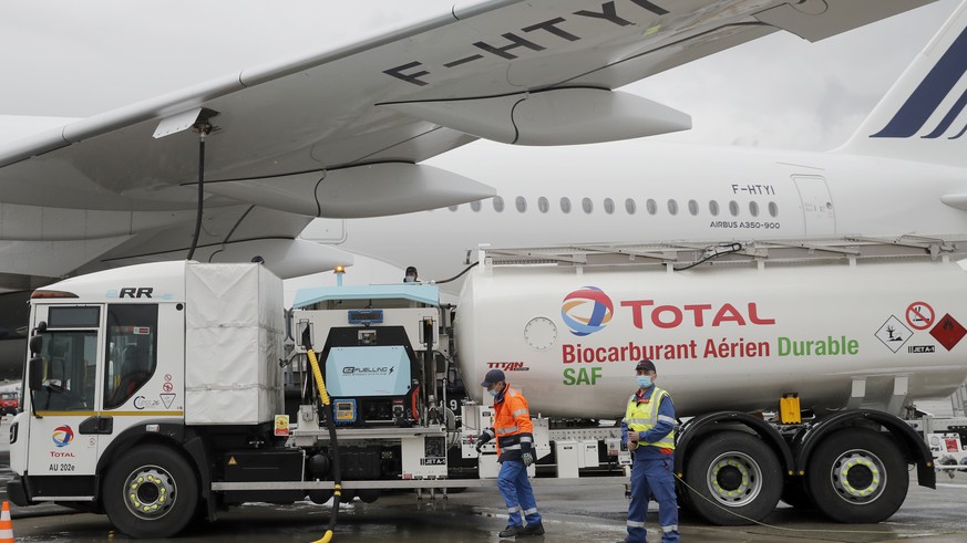 Workers refuel an Airbus A350 with sustainable aviation fuel at Roissy airport, north of Paris, Tuesday, May 18, 2021. Air France-KLM is sending into the air what it calls its first long-haul flight w ...