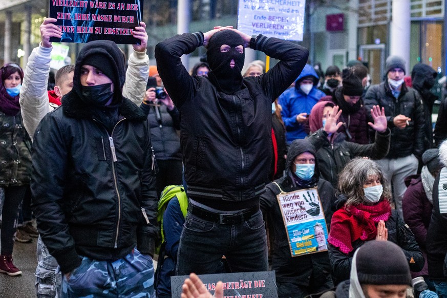 epa09621823 People take part in a protest against the coronavirus restrictions in front of the Alte Oper opera house in Frankfurt am Main, Germany, 04 December 2021. Germany is dealing with a rising n ...