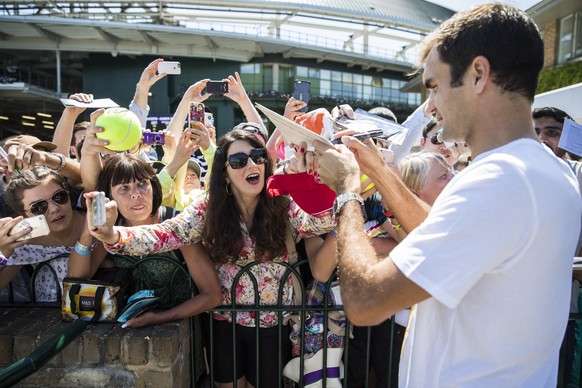 Roger Federer of Switzerland signs autographs for tennis fans after a training session at the All England Lawn Tennis Championships in Wimbledon, London, Wednesday, July 5, 2017. (KEYSTONE/Peter Klaun ...