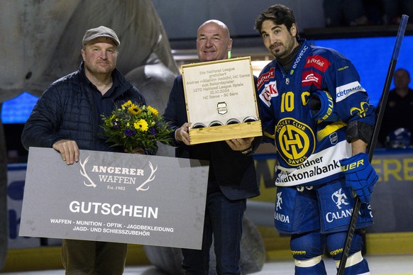 Der Davoser HCD Captain Andres Ambuehl, rechts wird von Denis Vaucher, (CEO Nationalliga), Mitte., und Marc Gianola, (CEO, HC Davos), links zu seinem 1270 Spiel als neuer Liga-Rekordspieler geehrt, vo ...