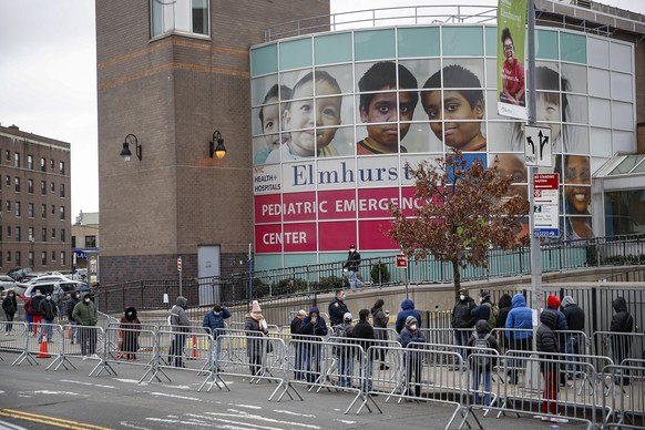 Patients wear personal protective equipment while maintaining social distancing as they wait in line for a COVID-19 test at Elmhurst Hospital Center, Wednesday, March 25, 2020, in New York. Gov. Andre ...