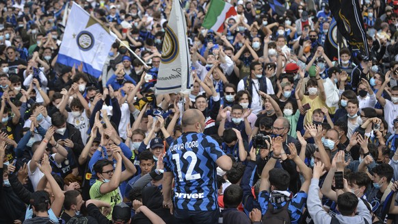 Inter Milan fans celebrate in Piazza Duomo square in front of the gothic cathedral after Inter Milan won its first Serie A title in more than a decade after second-placed Atalanta drew 1-1 at Sassuolo ...