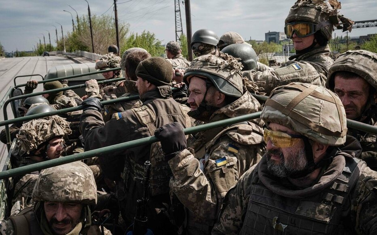 Des soldats ukrainiens dans un camion durant un transfert de troupes. En médaillon, Julien Grand, qui nous explique pourquoi mobiliser un million d'hommes est «irréaliste», malgré l'annonce du gouvern ...