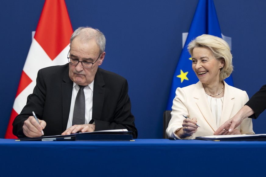 Swiss Federal President Guy Parmelin, left, and European Commission President Ursula von der Leyen sign a package of bilateral agreements between the European Union and Switzerland, in Brussels, Belgi ...