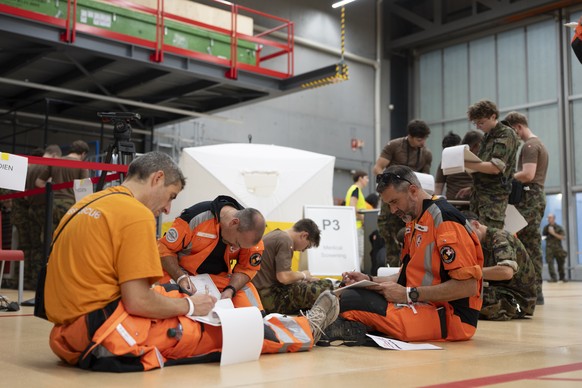 epa13064664 Members of the Swiss Rescue squad sign their contracts at the Zurich Airport in Kloten, Switzerland, 25 June 2026. The Rescue Squad, with 80 members, eight search dogs and 18 tonnes of res ...