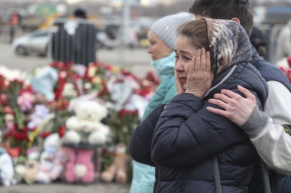 epa11242372 People mourn at the Crocus City Hall concert venue following a terrorist attack in Krasnogorsk, outside Moscow, Russia, 25 March 2024. At least 137 people were killed and more than 100 hos ...
