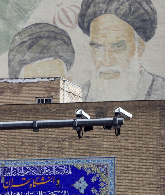 epa10567200 CCTV cameras seen in front of a picture of Iranian late supreme leader Ayatollah Ruhollah Khomeini in a street in Tehran, Iran, 10 April 2023. According to the Islamic Republic News Agency ...