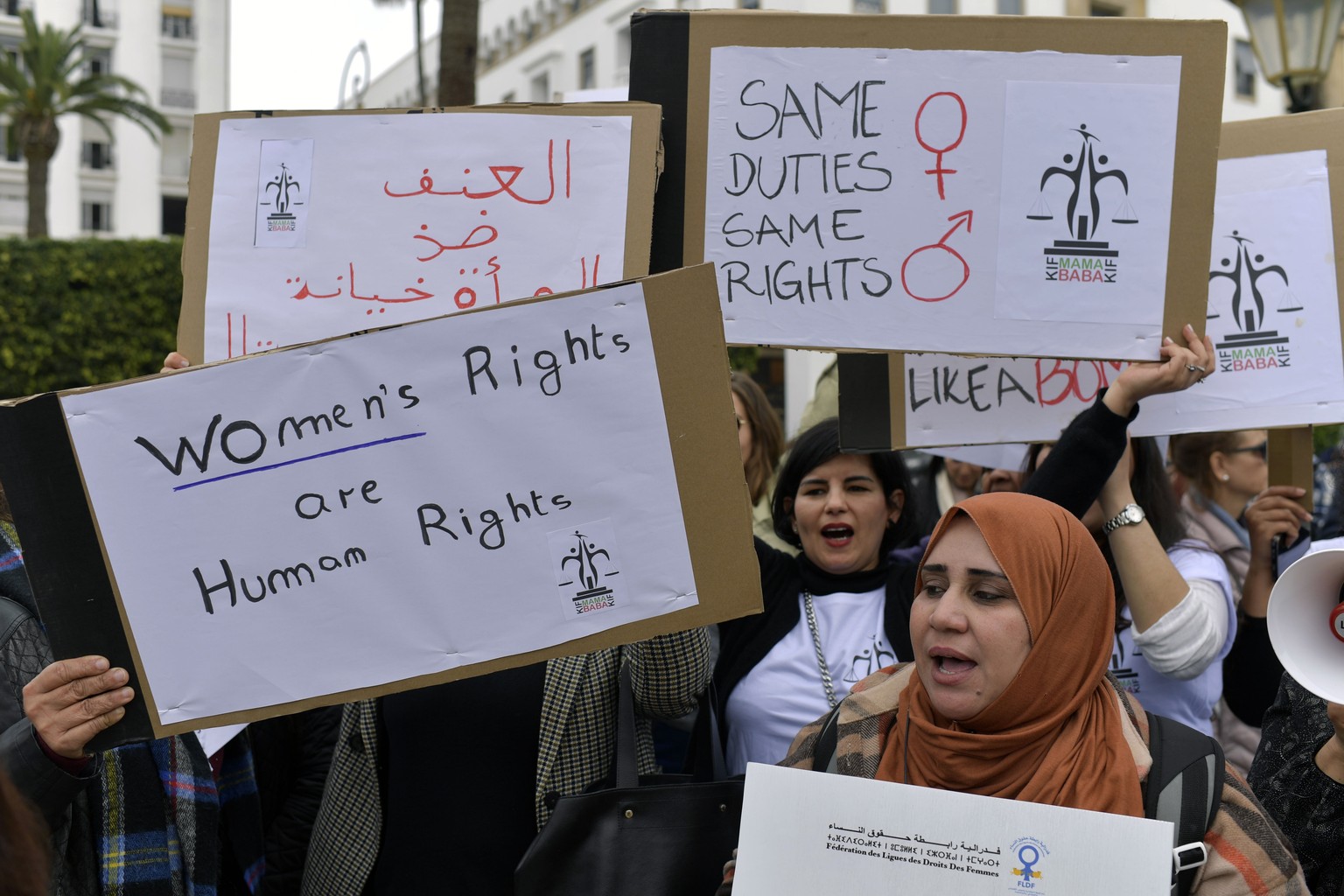 epa10509551 Moroccan woman carry placards, with one (back L), that reads &#039;violence against women is treason&#039; during a protest calling for gender equality as they mark International Women&#03 ...
