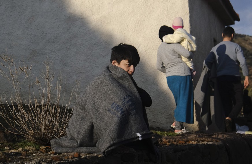 A migrant boy who arrived yesterday to Greece from Turkey, tries to warm himself at the village of Skala Sikaminias, on the Greek island of Lesbos on Friday, March 6, 2020. Thousands of refugees and o ...